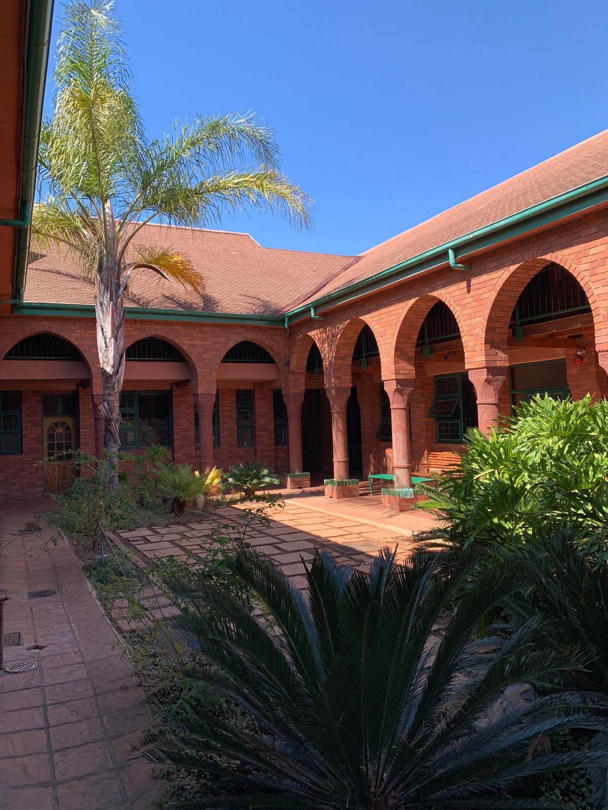 A shaded brick arcade around a planted courtyard