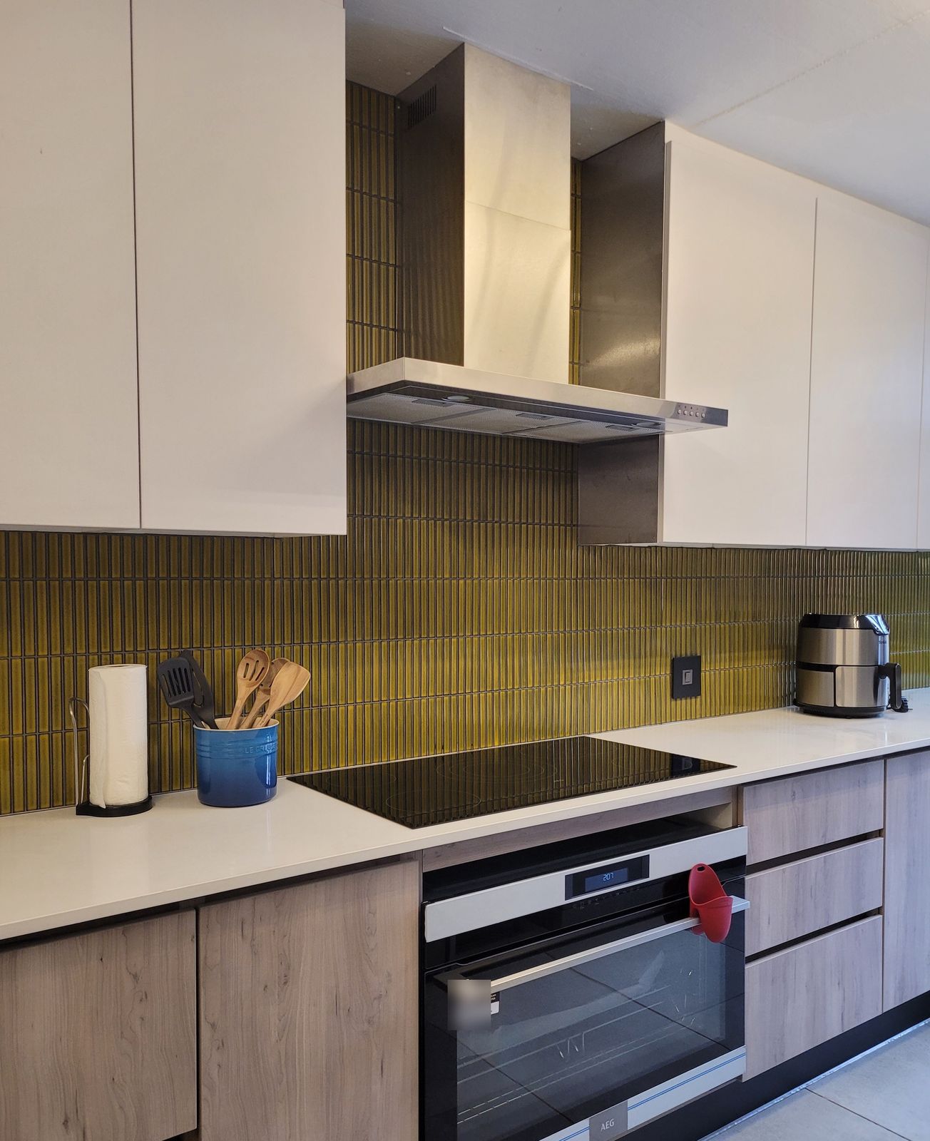 Handleless white cupboards over warm timber-look drawers
