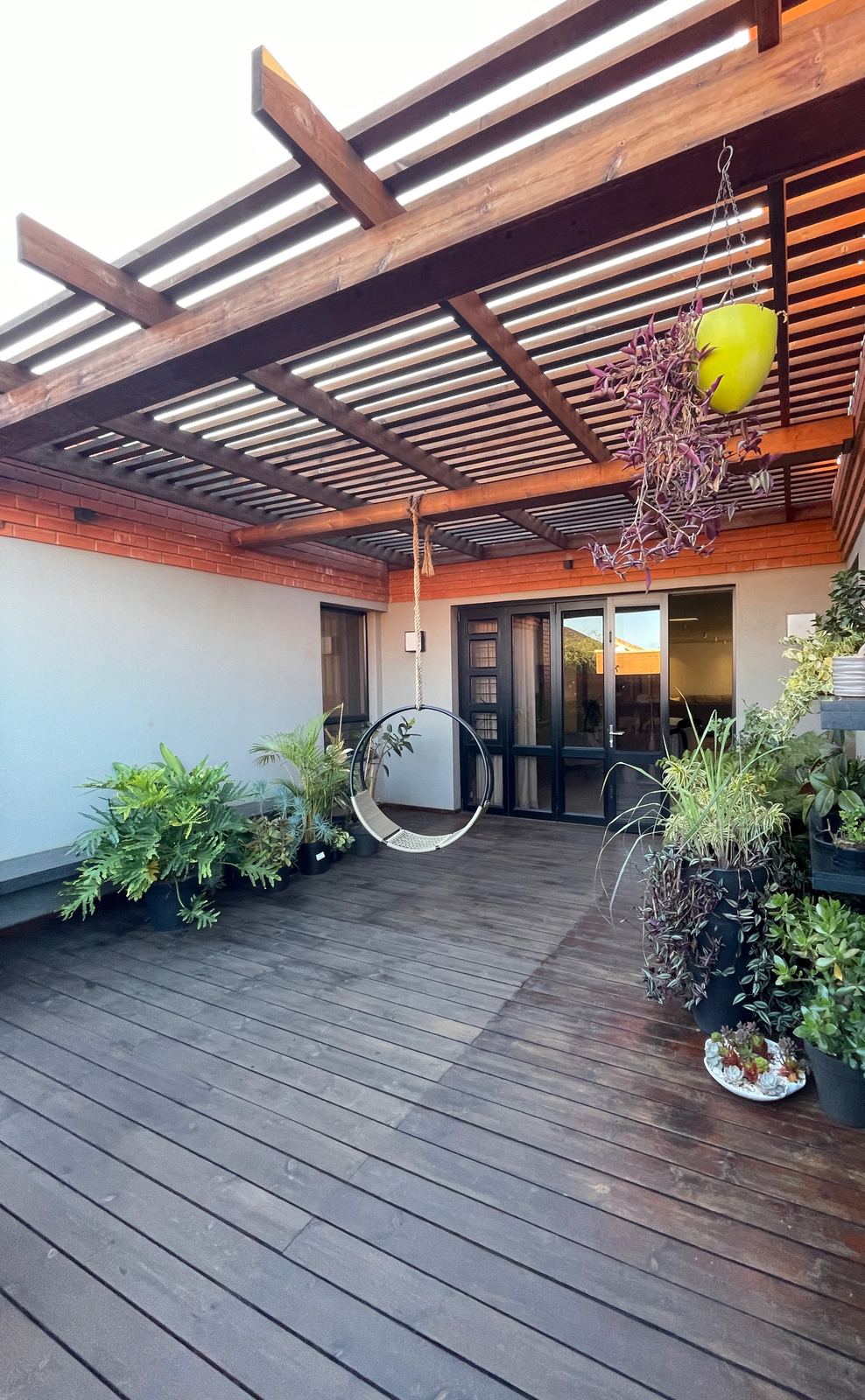 A timber deck under a slatted pergola