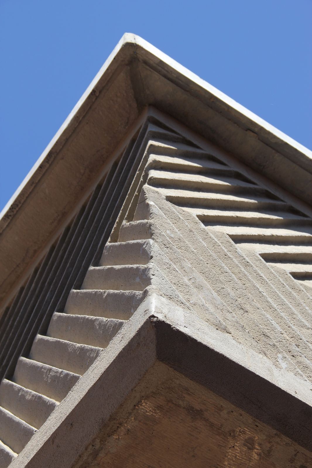 A relief-patterned parapet against the sky