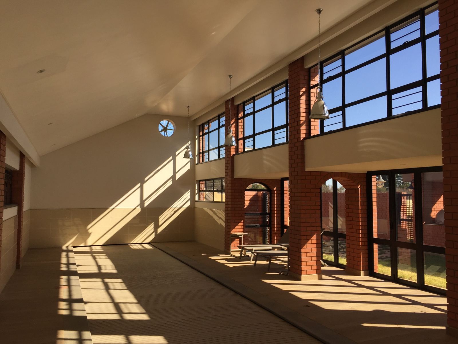 A double-volume garden room lit by high windows