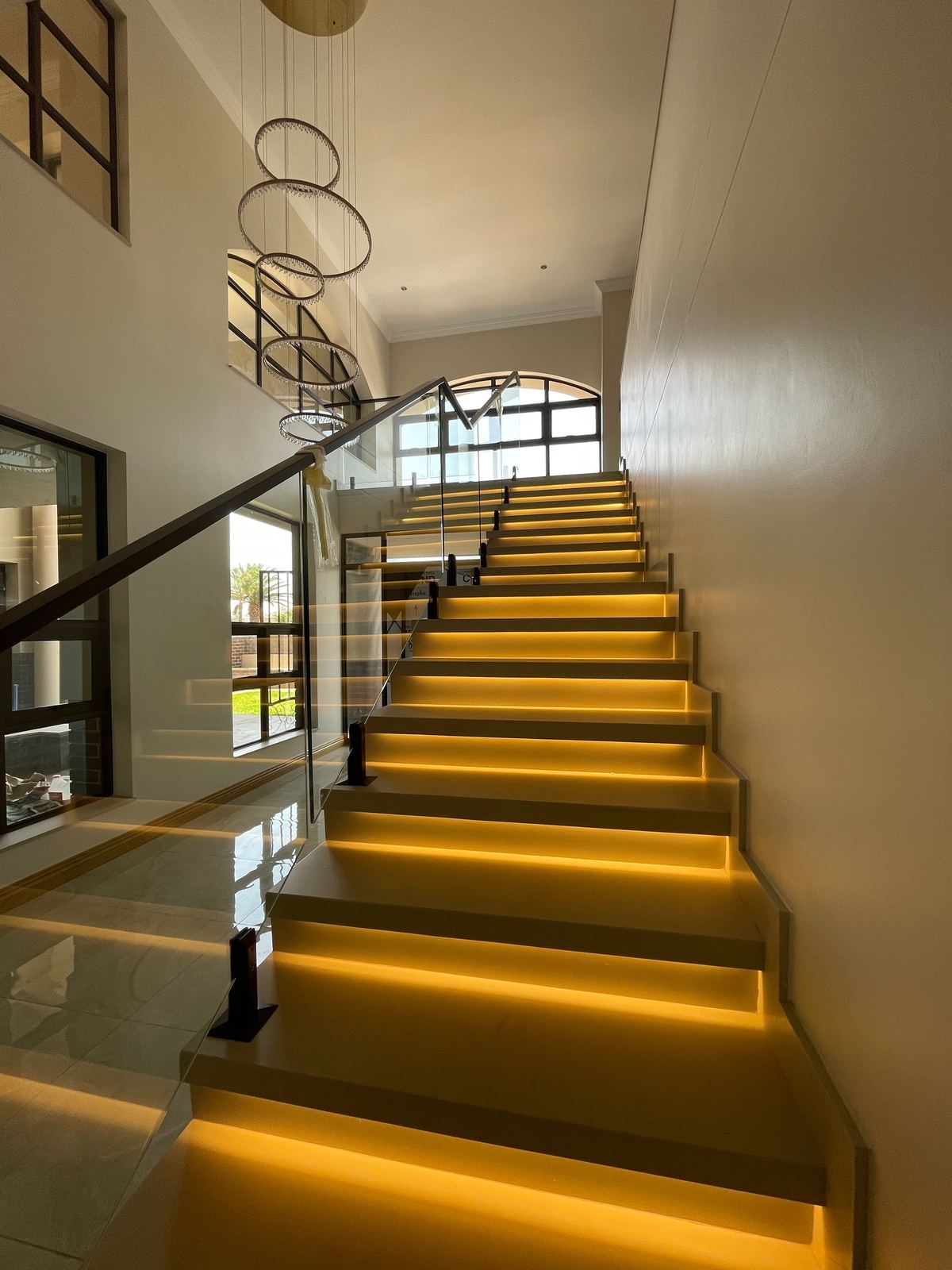 A sculptural lit staircase in a double-volume hall